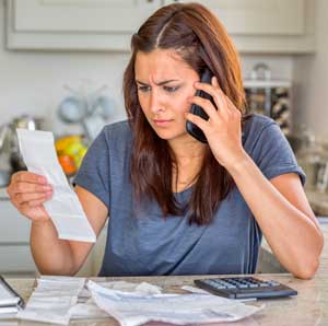 lowering premium expenses woman on phone stressed